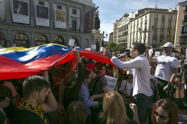 Casi un millar de opositores al gobierno venezolano se han concentrado hoy en la madrileña Plaza de Isabel II para solicitar a la comunidad internacional una mayor condena al presidente de su país Nicolás Maduro. EFE/Santi Donaire