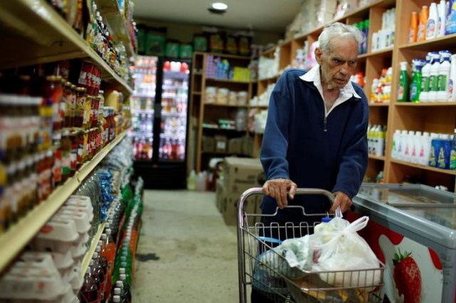 Una persona realizando compras en un supermercado en Caracas, mar 9, 2017. Los precios en Venezuela casi se han duplicado en los primeros cuatro meses del año, según un cálculo de la Asamblea Nacional, que busca suplir el vacío que dejaron el Banco Central y el Gobierno, que no han informado cifras oficiales de la economía desde hace más de un año.  REUTERS/Carlos Garcia Rawlins