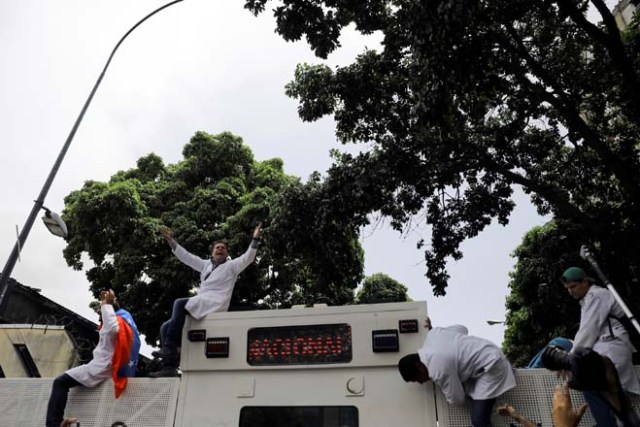 Demonstrators climb on a riot vehicle during a rally called by health care workers and opposition activists against Venezuela's President Nicolas Maduro in Caracas, Venezuela May 22, 2017. REUTERS/Carlos Barria