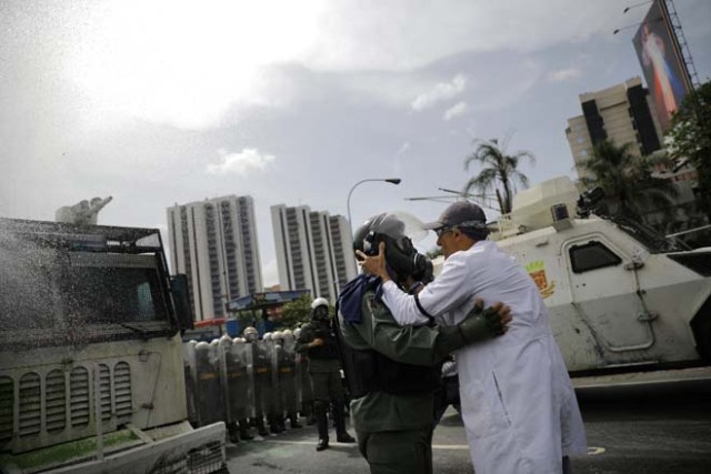 A demonstrator talks with a member of the Venezuelan National Guard during riots at a rally called by healthcare workers and opposition activists against Venezuela's President Nicolas Maduro in Caracas, Venezuela May 22, 2017. REUTERS/Carlos Barria TPX IMAGES OF THE DAY