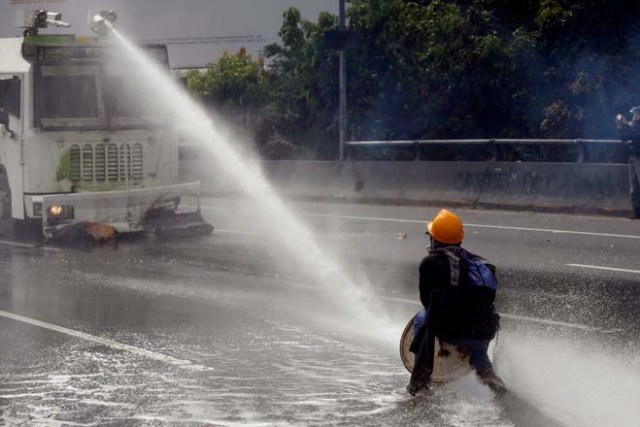 A demonstrator confronts a police water cannon vehicle during a rally called by health care workers and opposition activists against Venezuela's President Nicolas Maduro in Caracas, Venezuela May 22, 2017. REUTERS/Marco Bello