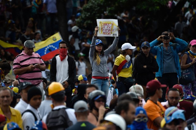 Opposition activists demonstrate against the government of Venezuelan President Nicolas Maduro in Caracas on June 24, 2017, in front of the Francisco de Miranda air force base near the place where a young man was shot dead by police during an anti-government rally two days ago. A political and economic crisis in the oil-producing country has spawned often violent demonstrations by protesters demanding Maduro's resignation and new elections. The unrest has left 75 people dead since April 1. / AFP PHOTO / Juan BARRETO