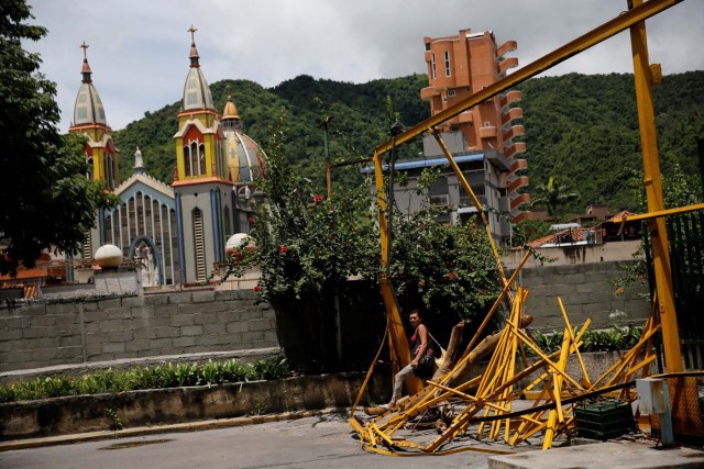 A woman walks through a broken main gate after opposition supporters and security forces clashed in and outside residential buildings on Tuesday according to residents, in Caracas, Venezuela June 14, 2017. REUTERS/Ivan Alvarado