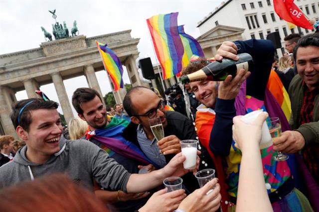 Foto: arias personas celebran la aprobación de la legalización del matrimonio homosexual en el Parlamento ante la Puerta de Brandemburgo en Berlín (Alemania) hoy, 30 de junio de 2017. El pleno de la Cámara baja alemana aprobó hoy la legalización del matrimonio homosexual, un proyecto impulsado por los socialdemócratas rompiendo el acuerdo de coalición con los conservadores de la canciller, Angela Merkel. EFE/Felipe Trueba 