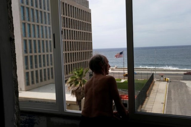 Un hombre mira a través de su ventana a la embajada estadounidense en La Habana, Cuba. 13 de junio 2017. Los cubanos lamentaron el viernes el retorno a una era más fría en las relaciones con Estados Unidos, tras  conocer que el presidente Donald Trump está próximo a anunciar un plan para endurecer normas sobre viajes y negocios en la isla, revirtiendo parte de una histórica distensión bajo el gobierno previo. REUTERS/Stringer