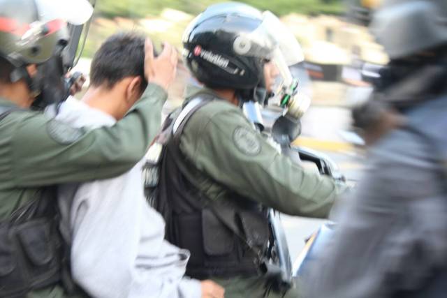 GNB cubriendo el rostro de un manifestante detenido en Altamira. Foto: Régulo Gómez / LaPatilla.com