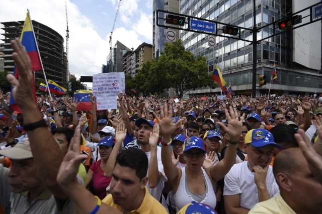 Opposition activists demonstrate against Venezuelan President Nicolas Maduro in Caracas, on July 9, 2017. Venezuela hit its 100th day of anti-government protests on Sunday, one day after its most prominent political prisoner, Leopoldo Lopez, vowed to continue his fight for freedom after being released from jail and placed under house arrest. At least 91 people have died since non-stop street protests began on April 1. / AFP PHOTO / Juan BARRETO