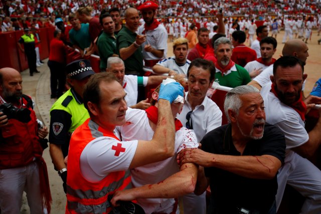 A reveller injured by a wild cow is taken away from the bullring following the seventh running of the bulls at the San Fermin festival in Pamplona, northern Spain, July 13, 2017. REUTERS/Susana Vera