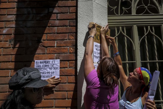 CAR11. CARACAS (VENEZUELA), 24/07/2017.- Manifestantes pegan carteles en rechazo a la Asamblea Constituyente hoy, lunes 24 de julio de 2017, en un colegio electoral de Caracas (Venezuela). Venezuela inicia hoy la semana decisiva para la elección de la Asamblea Nacional Constituyente convocada por el presidente, Nicolás Maduro, con los oficialistas entrando en la recta final de su campaña en medio de protestas y llamados a paro de los opositores en rechazo a esos comicios. EFE/Miguel Gutiérrez