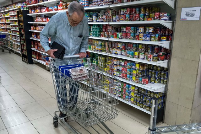 CAR24. CARACAS (VENEZUELA), 24/07/2017.- Personas buscan alimentos en un supermercado con estanterías con alimentos repetidos hoy, lunes 24 de julio de 2017, en Caracas (Venezuela). Numerosos supermercados de Caracas cerrarán hoy con más estanterías vacías de lo habitual después de que los habitantes de la capital hicieran acopio de alimentos y otros productos básicos ante el paro general contra el Gobierno que la oposición convocó para el miércoles y el jueves. EFE/MIGUEL GUTIÉRREZ