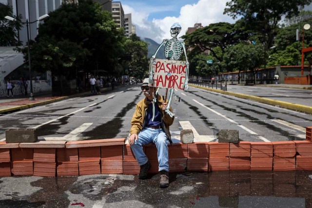 CAR04. CARACAS (VENEZUELA), 28/07/2017.- Un hombre protesta en la calle hoy, viernes 28 de julio de 2017, en Caracas (Venezuela). La oposición venezolana promueve hoy una gran protesta nacional atrancando las calles y avenidas, una convocatoria que reta la prohibición de las autoridades a que se celebre cualquier tipo de reunión pública que perturbe los comicios. EFE/Miguel Gutiérrez