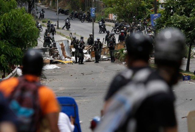 Demonstrators face security forces members (rear) as clashes break out while the Constituent Assembly election is being carried out in Caracas, Venezuela, July 30, 2017. REUTERS/Marco Bello