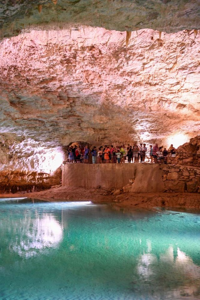 People visit a natural cave in Choranche, in the Vercors region near Grenoble, on August 3, 2017. Since the beginning of the heat wave, there has been an increase of at least 10 percent in the number of cave visitors, looking for beautiful natural sites, but also for underground freshness with temperatures around 15 Degrees Celsius. / AFP PHOTO / JEAN-PIERRE CLATOT