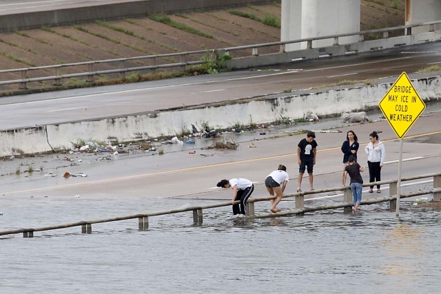 People view the flooded highways in Houston on August 27, 2017 as the city battles with tropical storm Harvey and resulting floods. Massive flooding unleashed by deadly monster storm Harvey left Houston -- the fourth-largest city in the United States -- increasingly isolated Sunday as its airports and highways shut down and residents fled homes waist-deep in water. / AFP PHOTO / Thomas B. Shea