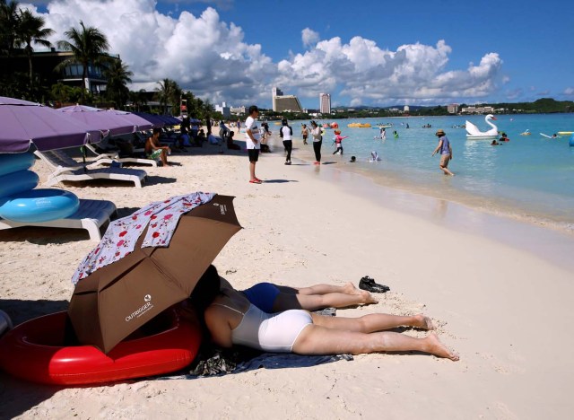 Tourists enjoy the beach in the Tumon tourist district on the island of Guam, a U.S. Pacific Territory, August 12, 2017. REUTERS/Erik De Castro