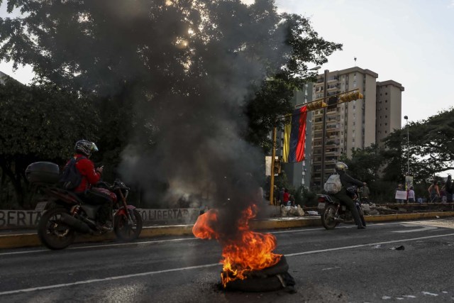 CAR08. CARACAS (VENEZUELA), 10/08/2017.- Manifestantes queman una llanta durante una protesta opositora hoy, jueves 10 de agosto de 2017, en Caracas (Venezuela). El destituido alcalde opositor David Smolansky, autoridad local del municipio El Hatillo de Caracas, llamó hoy a los habitantes de esa localidad a protestar luego de que el Tribunal Supremo le destituyese y le condenará a 15 meses de prisión por permitir protestas y cierres de vías. EFE/Miguel Gutiérrez