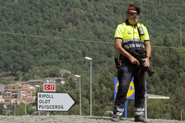 GRA165 RIPOLL (Girona), 20/8/2017. Un Mossos d'Esquadra en la C-17 a su paso por Ripoll (Girona) donde se han registrado tres kilómetros de colas debido a los controles policiales que se realizan en el marco de la operación de cierre de la provincia de Girona por la investigación de los atentados de Barcelona y Cambrils (Tarragona).Además de los accesos a esa localidad, donde residían Younes Abouyaaqoub, uno de los terroristas huidos, y otros de los yihadistas fallecidos. EFE/Robin Townsend