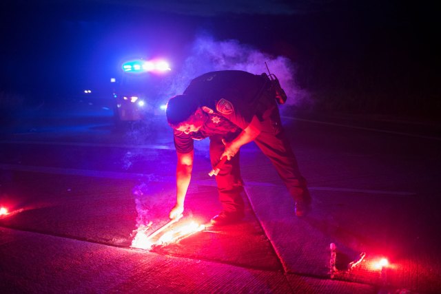 Un policía coloca balizas de seguridad para bloquear el camino a la planta de Arkema afectada por la tormenta tropical Harvey, en Crosby, Texas, EEUU. August 31, 2017. REUTERS/Adrees Latif