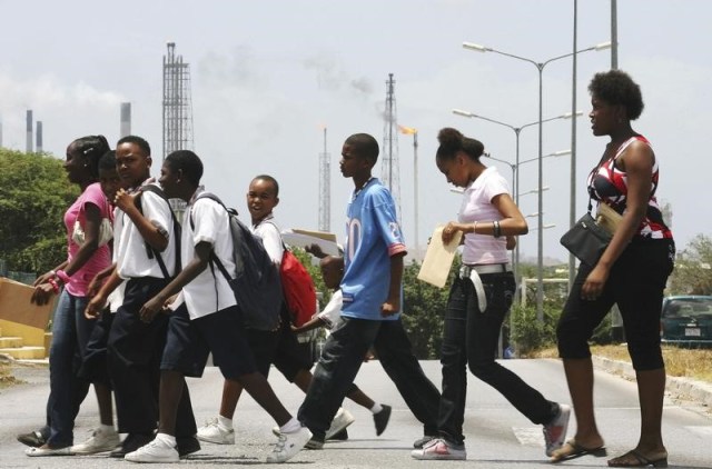 Niños caminan frente a la refinería Isla en Willemstad en Curazao. 17 de junio de 2008.  REUTERS/Jorge Silva