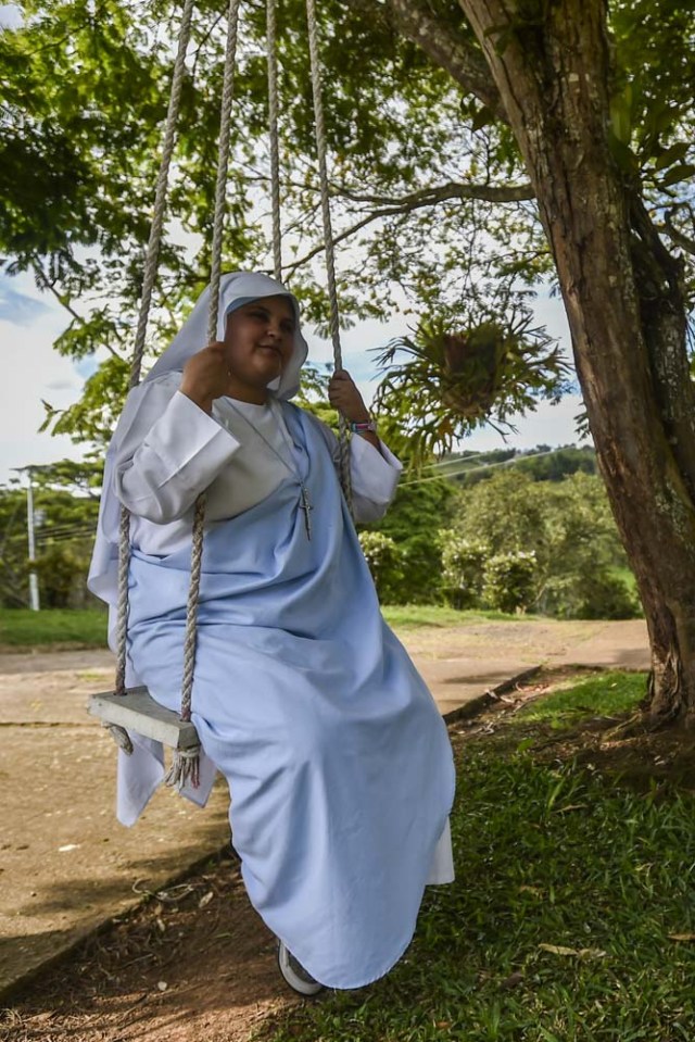 Nun Maria Valentina de los Angeles, of the ?Comunicadoras Eucaristicas del Padre Celestial? (Eucharistic Communicators of the Celestial Father) congregation, sits on a swing at a convent in the outskirts of Cali, Colombia, on July 17, 2017. Nun Maria Valentina de los Angeles ?who wears tennis shoes, raps and already participated in a reality show- will see her dream of singing to Pope Francis come true during his visit to Colombia. / AFP PHOTO / Luis ROBAYO / TO GO WITH AFP STORY BY RODRIGO ALMONACID