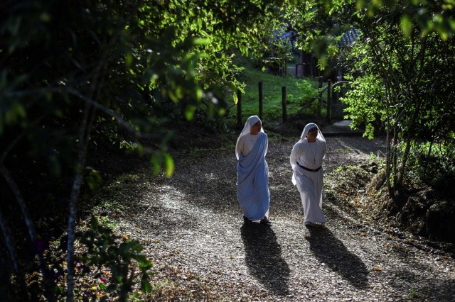 Fellow nuns of Maria Valentina de los Angeles, of the ?Comunicadoras Eucaristicas del Padre Celestial? (Eucharistic Communicators of the Celestial Father) congregation, walk at a convent in the outskirts of Cali, Colombia, on July 17, 2017. Nun Maria Valentina de los Angeles ?who wears tennis shoes, raps and already participated in a reality show- will see her dream of singing to Pope Francis come true during his visit to Colombia. / AFP PHOTO / Luis ROBAYO / TO GO WITH AFP STORY BY RODRIGO ALMONACID