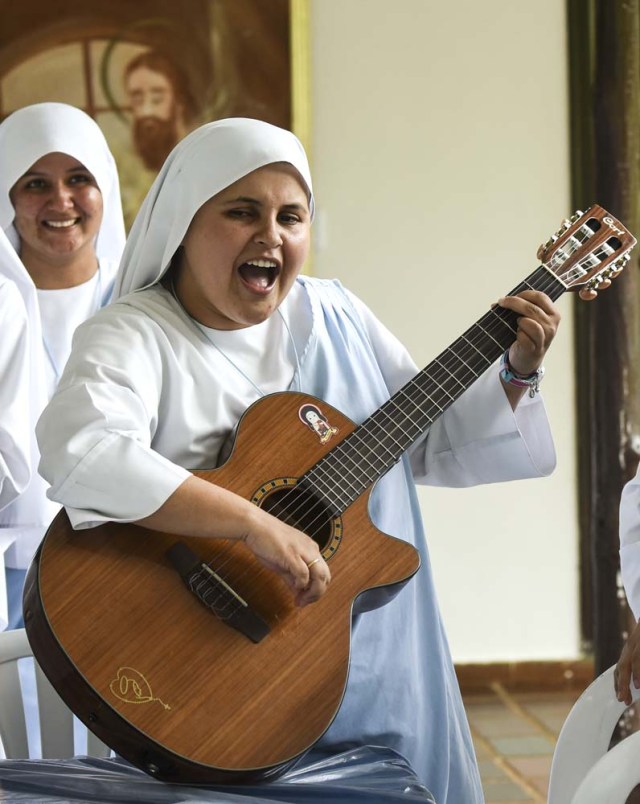 Nun Maria Valentina de los Angeles, of the ?Comunicadoras Eucaristicas del Padre Celestial? (Eucharistic Communicators of the Celestial Father) congregation, plays the guitar and sings at a convent in the outskirts of Cali, Colombia, on July 17, 2017. Nun Maria Valentina de los Angeles ?who wears tennis shoes, raps and already participated in a reality show- will see her dream of singing to Pope Francis come true during his visit to Colombia. / AFP PHOTO / Luis ROBAYO / TO GO WITH AFP STORY BY RODRIGO ALMONACID