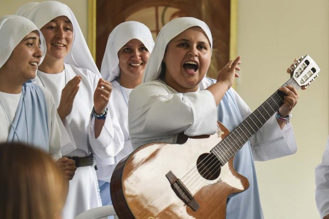 Nun Maria Valentina de los Angeles (R), of the ?Comunicadoras Eucaristicas del Padre Celestial? (Eucharistic Communicators of the Celestial Father) congregation, plays the guitar and sings at a convent in the outskirts of Cali, Colombia, on July 17, 2017. Nun Maria Valentina de los Angeles ?who wears tennis shoes, raps and already participated in a reality show- will see her dream of singing to Pope Francis come true during his visit to Colombia. / AFP PHOTO / Luis ROBAYO / TO GO WITH AFP STORY BY RODRIGO ALMONACID