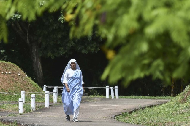 A fellow nun of Maria Valentina de los Angeles, of the ?Comunicadoras Eucaristicas del Padre Celestial? (Eucharistic Communicators of the Celestial Father) congregation, walks at a convent in the outskirts of Cali, Colombia, on July 17, 2017. Nun Maria Valentina de los Angeles ?who wears tennis shoes, raps and already participated in a reality show- will see her dream of singing to Pope Francis come true during his visit to Colombia. / AFP PHOTO / Luis ROBAYO / TO GO WITH AFP STORY BY RODRIGO ALMONACID