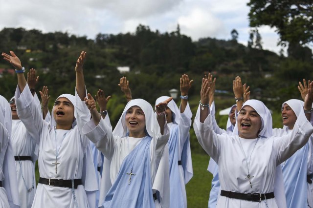 Fellow nuns of Maria Valentina de los Angeles, of the ?Comunicadoras Eucaristicas del Padre Celestial? (Eucharistic Communicators of the Celestial Father) congregation, perform during the recording of a music video at a convent in the outskirts of Cali, Colombia, on July 17, 2017. Nun Maria Valentina de los Angeles ?who wears tennis shoes, raps and already participated in a reality show- will see her dream of singing to Pope Francis come true during his visit to Colombia. / AFP PHOTO / Luis ROBAYO / TO GO WITH AFP STORY BY RODRIGO ALMONACID