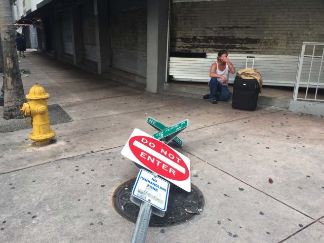 A victim of Hurricane Irma sits at a store front on September 11, 2017, in Miami. Irma weakened early Monday to a tropical storm as it continued on a northward path through Florida, the National Hurricane Center said. As of 8 am (1200 GMT), Irma was about 105 miles (170 kilometers) northwest of Tampa, with maximum sustained winds of 70 miles per hour (110 kilometers per hour). Early reports of Irma's aftermath seemed to show that damage in Florida from the massive storm were not as bad as initially feared. / AFP PHOTO / Michele Eve SANDBERG