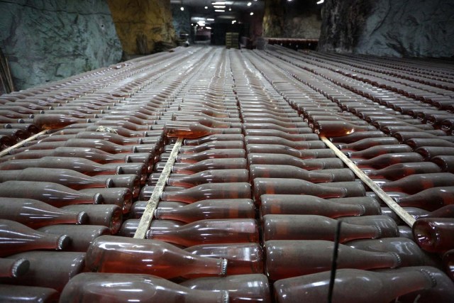 A picture taken on July 12, 2017 shows bottles of wine in the "Artwinery" winery firm in the eastern Ukrainian city of Bakhmut. The winery is located in a government-held town just two dozen kilometres (15 miles) from the frontline in Ukraine's low-level war, where the army and Russian-backed rebels continue to lob deadly artillery barrages at each other. The town spent around a month under rebel control in 2014, and in 2015 the frontline was so close that the town came under rebel shelling. But despite more than three years of fighting that has claimed some 10,000 lives, Nasyrov's employer, Artwinery, has never stopped production. / AFP PHOTO / Aleksey FILIPPOV