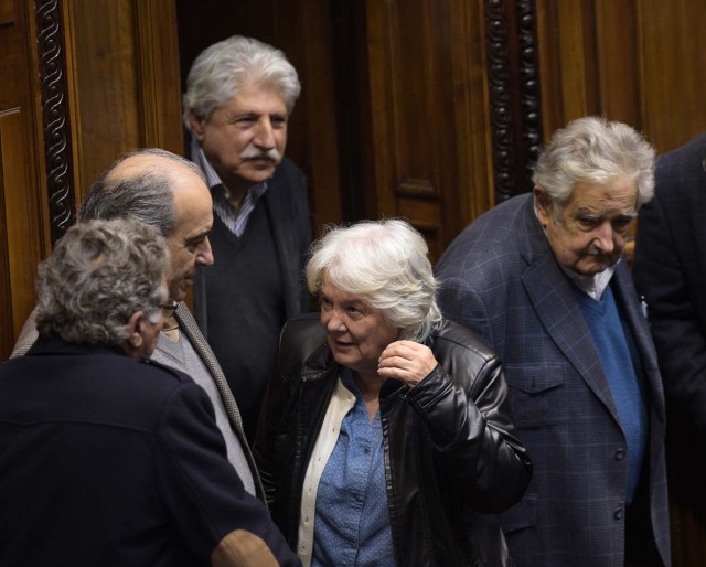 Uruguay's new vice-president Lucia Topolansky (C), accompanied by her husband, senator and former president Jode Mujica (R), talk with fellow lawmakers after her swearing-in ceremony in Montevideo, on September 13, 2017. Topolansky replaces Raul Sendic, who resigned on Saturday over allegations he used public money for personal shopping. / AFP PHOTO / MIGUEL ROJO