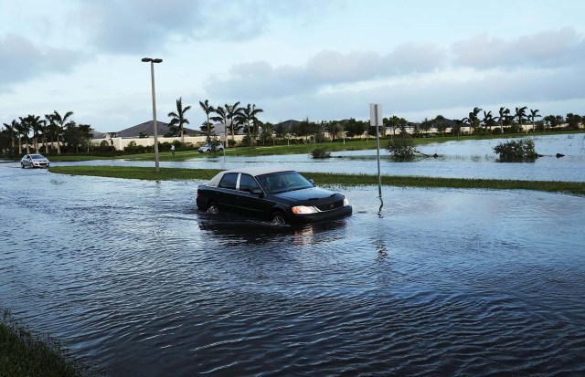 BONITA SPRINGS, FL - SEPTEMBER 11: Cars make their away through a flooded street the morning after Hurricane Irma swept through the area on September 11, 2017 in Bonita Springs, Florida. Hurricane Irma made another landfall near Naples yesterday after inundating the Florida Keys. Electricity was out in much of the region with localized flooding. Spencer Platt/Getty Images/AFP