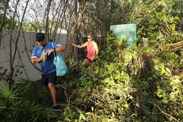 NAPLES, FL - SEPTEMBER 11: People walk through downed trees the morning after Hurricane Irma swept through the area on September 11, 2017 in Fort Myers, Florida. Hurricane Irma made another landfall near Naples yesterday after inundating the Florida Keys. Electricity was out in much of the region with localized flooding. Spencer Platt/Getty Images/AFP