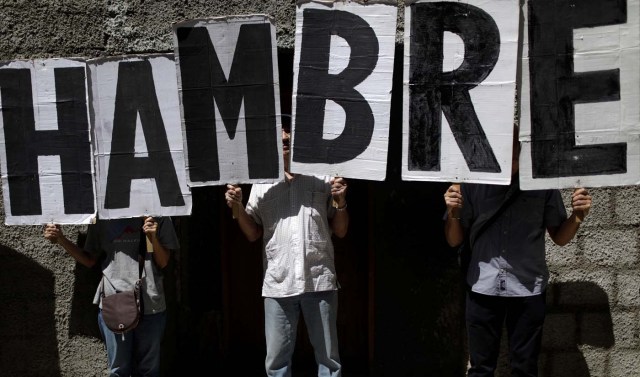 People hold letters which read "Hunger" during a protest outside the World Health Organization (WHO) office in Caracas, Venezuela September 25, 2017. REUTERS/Ricardo Moraes