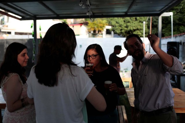 People drink craft beer in a beer garden at the garage of Social Club brewery in Caracas, Venezuela, September 15, 2017. Picture taken September 15, 2017. REUTERS/Marco Bello