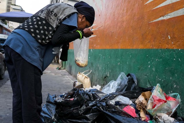 ACOMPAÑA CRÓNICA: VENEZUELA CRISIS. CAR08. CARACAS (VENEZUELA), 25/09/2017.- Fotografía fechada el 20 de septiembre de 2017 que muestra a una mujer mientras hurga en una basura en busca de comida en una calle de Caracas (Venezuela). En las calles de Caracas deambulan cada vez más niños y de menos edad. Se trata, según analistas y activistas de derechos humanos, de una nueva oleada de pequeños que prácticamente han abandonado sus hogares, aunque esta vez la razón es una sola: "La falta de comida en sus casas". EFE/Miguel Gutiérrez