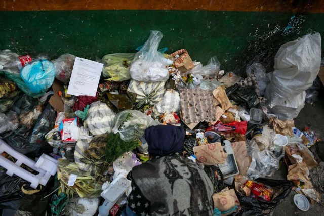 ACOMPAÑA CRÓNICA: VENEZUELA CRISIS. CAR10. CARACAS (VENEZUELA), 25/09/2017.- Fotografía fechada el 20 de septiembre de 2017 que muestra a una mujer mientras hurga en una basura en busca de comida en una calle de Caracas (Venezuela). En las calles de Caracas deambulan cada vez más niños y de menos edad. Se trata, según analistas y activistas de derechos humanos, de una nueva oleada de pequeños que prácticamente han abandonado sus hogares, aunque esta vez la razón es una sola: "La falta de comida en sus casas". EFE/Miguel Gutiérrez