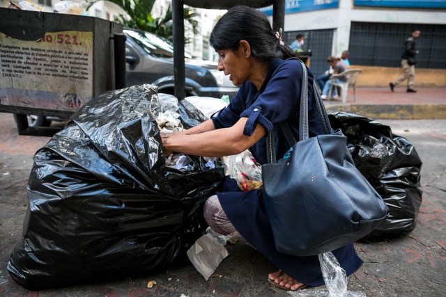 ACOMPAÑA CRÓNICA: VENEZUELA CRISIS. CAR02. CARACAS (VENEZUELA), 25/09/2017.- Fotografía fechada el 20 de septiembre de 2017 que muestra a una mujer mientras hurga en una basura en busca de comida en una calle de Caracas (Venezuela). En las calles de Caracas deambulan cada vez más niños y de menos edad. Se trata, según analistas y activistas de derechos humanos, de una nueva oleada de pequeños que prácticamente han abandonado sus hogares, aunque esta vez la razón es una sola: "La falta de comida en sus casas". EFE/Miguel Gutiérrez