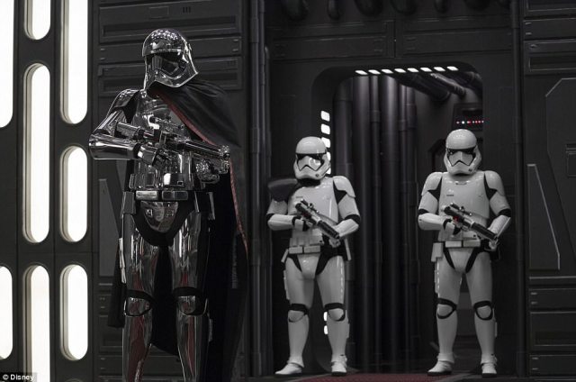 Evil lady_ Captain Phasma (played by Gwendoline Christie) is in her full metal costume as she poses with two Stormtroopers