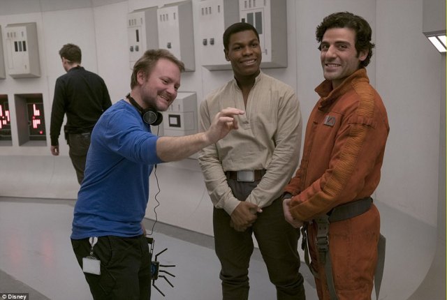 The guy in charge_ The film is written and directed by Rian Johnson; here he is seen with Boyega and Isaac