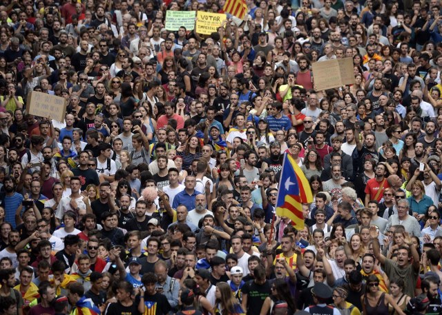 Protesters gather in front of the Spanish National Police headquarters during a general strike in Catalonia called by Catalan unions in Barcelona, on October 3, 2017. Large numbers of Catalans are expected to observe a general strike today to condemn police violence at a banned weekend referendum on independence, as Madrid comes under growing international pressure to resolve its worst political crisis in decades. / AFP PHOTO / Josep LAGO