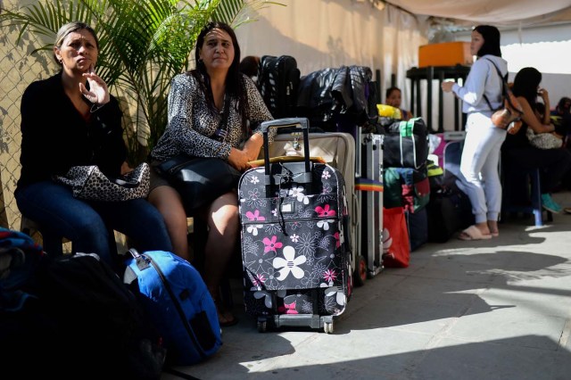 People queue to buy tickets to travel to Ecuador at a bus terminal in Caracas, on October 11, 2017 as scores of disappointed Venezuelans who see no end to the crisis choose to leave the country. Venezuela, which holds regional elections on October 15, is a country at the top of the Latin American continent that is in deep economic and political crisis. / AFP PHOTO / Federico PARRA