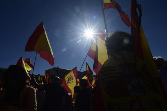 La gente agita banderas españolas durante una manifestación llamando a la unidad en Madrid el 28 de octubre de 2017, un día después de que se impuso el control directo sobre Cataluña en un intento por separarse de España. España se movió para afirmar el dominio directo sobre Cataluña, reemplazando a sus funcionarios ejecutivos y altos para sofocar un impulso de independencia que ha sumido al país en una crisis y ha puesto nerviosa a la Europa secesionista. / AFP PHOTO / JAVIER SORIANO