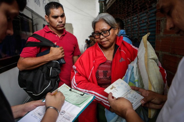 ACOMPAÑA CRÓNICA: VENEZUELA CRISIS - CAR02. CARACAS (VENEZUELA), 05/10/2018.- Fotografía del 29 de septiembre de 2017, que muestra a una mujer que presenta tu pase para abordar uno de los autobuses en Caracas (Venezuela) con destino a diferentes países suramericanos. La reducción de oferta y el alto costo de boletos aéreos internacionales han obligado a muchos venezolanos a migrar por vía terrestre a diferentes países de Suramérica en búsqueda de alimentos, salud, seguridad y un "futuro", un viaje que puede tomar entre día y medio y once días, dependiendo qué tan al sur quieran llegar. EFE/Cristian Hernández