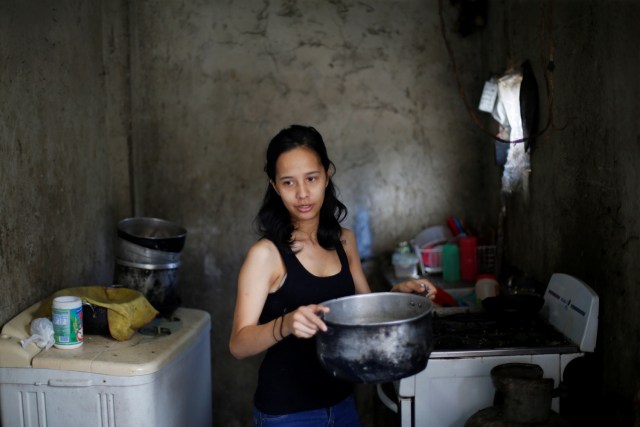 Yennifer Padrón lleva agua caliente para un baño en su casa en la favela de Petare en Caracas, Venezuela, 21 de agosto de 2017. Foto tomada el 21 de agosto de 2017. Para coincidir con la característica VENEZUELA-NIÑOS / REUTERS / Andres Martínez Casares