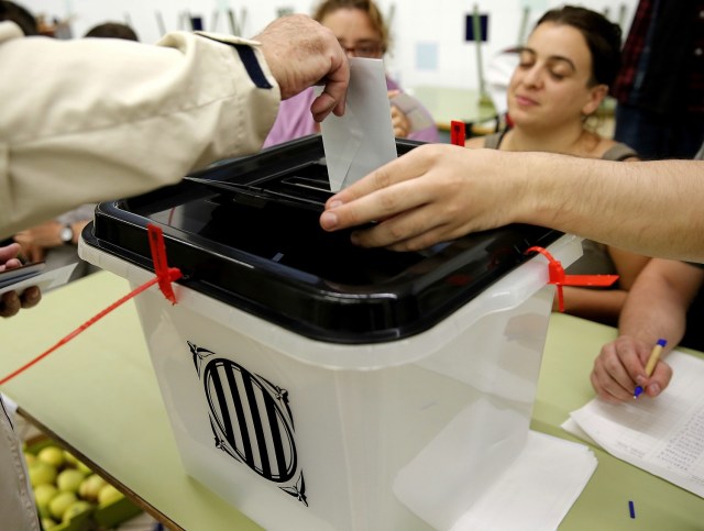 GRA144 BARCELONA, 01/10/2017.- Un ciudadano deposita su voto para el referéndum indepedentista suspendido por el Tribunal Constitucional en la Escola Collaso i Gil de Barcelona. EFE/Juan Carlos Cárdenas