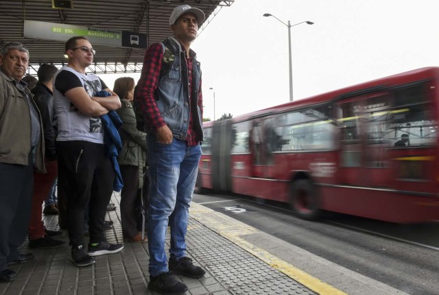 Venezuelan national Jhonger Pina, 25, awaits at a bus station in Bogota, before getting a bus to sell candies and show Bolivar bills as a curiosity to passengers in exchange for local coins, on October 26, 2017. Up to October 2017 there were 470,000 Venezuelans in Colombia, who left their country to escape the hardship and violence of its economic and political crisis. / AFP PHOTO / Raul Arboleda / TO GO WITH AFP STORY by Daniela QUINTERO and Santiago TORRADO