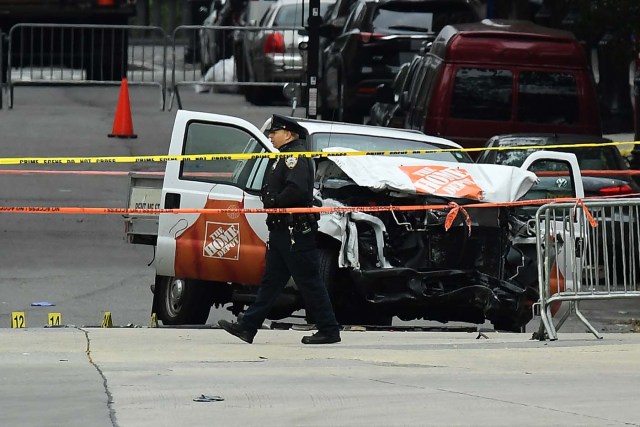 A police officer walks past the wreckage of a Home Depot pickup truck, a day after it was used in an terror attack, in New York on November 1, 2017. The pickup truck driver who plowed down a New York cycle path, killing eight people, in the city's worst attack since September 11, was associated with the Islamic State group but "radicalized domestically," the state's governor said Wednesday. The driver, identified as Uzbek national named Sayfullo Saipov was shot by police in the stomach at the end of the rampage, but he was expected to survive. / AFP PHOTO / Jewel SAMAD