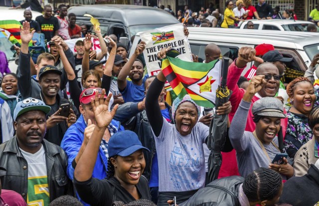 People shout slogans and wave Zimbabwean national flags during a demonstration demanding the resignation of Zimbabwe's president on November 18, 2017 in Harare. Zimbabwe was set for more political turmoil November 18 with protests planned as veterans of the independence war, activists and ruling party leaders called publicly for President Robert Mugabe to be forced from office. / AFP PHOTO / Jekesai NJIKIZANA